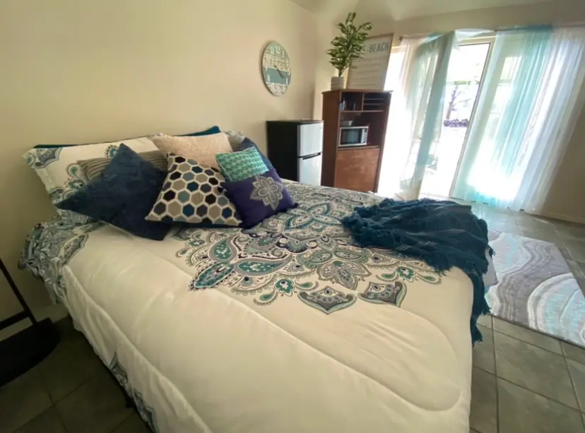 A guest bedroom made up with teal bedding